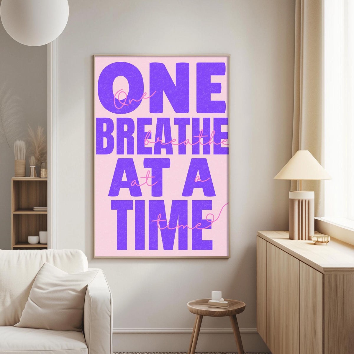 a poster with the text "One breath at a time" in large purple letters on a pink background.