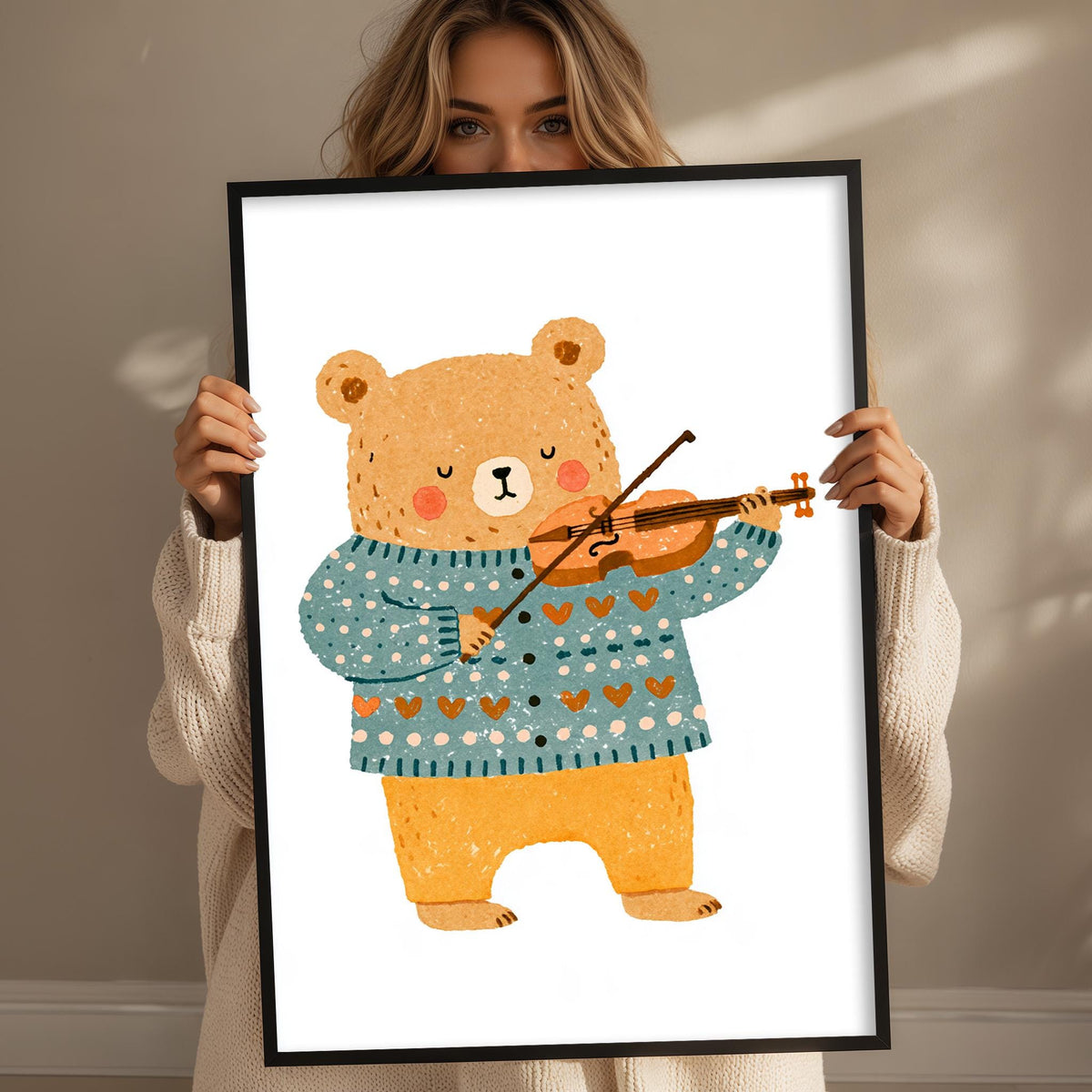 A woman is holding up a framed illustration of a bear playing a violin.