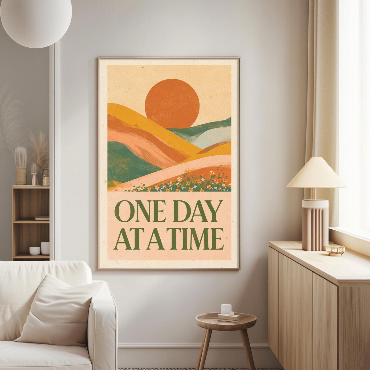 a poster with a landscape scene and the text "ONE DAY AT A TIME" hanging on a wall in a living room.