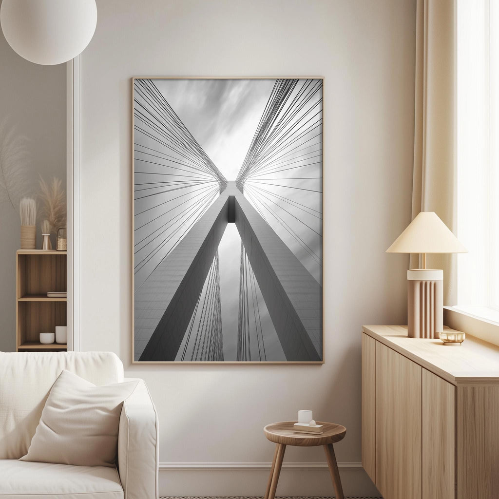 a large black and white photograph of a bridge with a striking design, hanging on a wall in a modern living room.