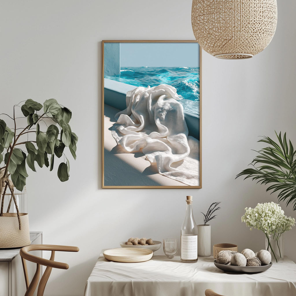 a serene indoor setting with a framed picture of a white towel hanging on a wall, a table with a vase of white flowers, and a potted plant.