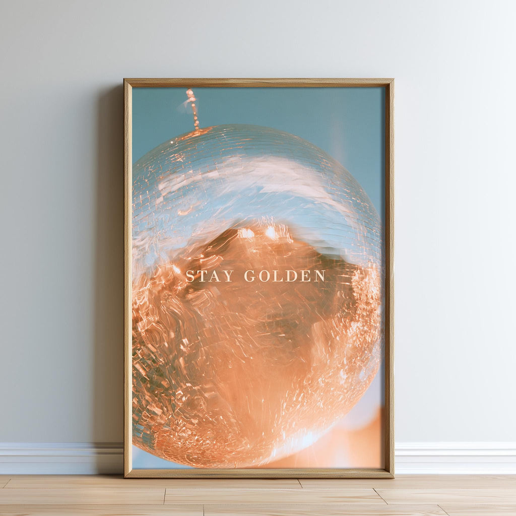a framed photograph of a glass sphere with a golden hue, set against a blue background.