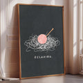 A framed poster with a black background and a pink ball of yarn with a crochet hook on top, along with the text "RELAXING."