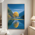 a large framed picture of a tree with yellow leaves, reflected in a calm lake, creating a serene and picturesque scene.