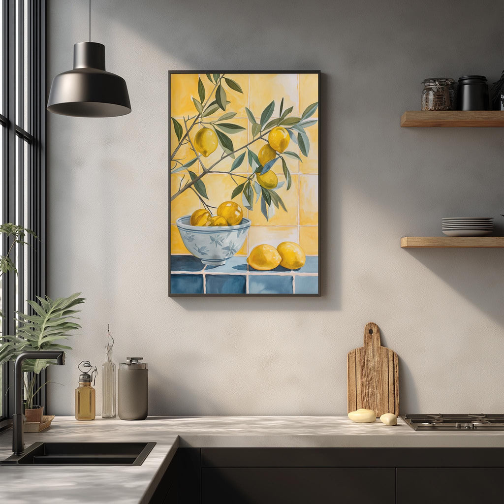a kitchen counter with a framed painting of lemons hanging on the wall above it. The painting depicts a bowl filled with lemons, and there are additional lemons on the counter. The kitchen also includes a sink, a wooden cutting board, and some decorative items on the counter.