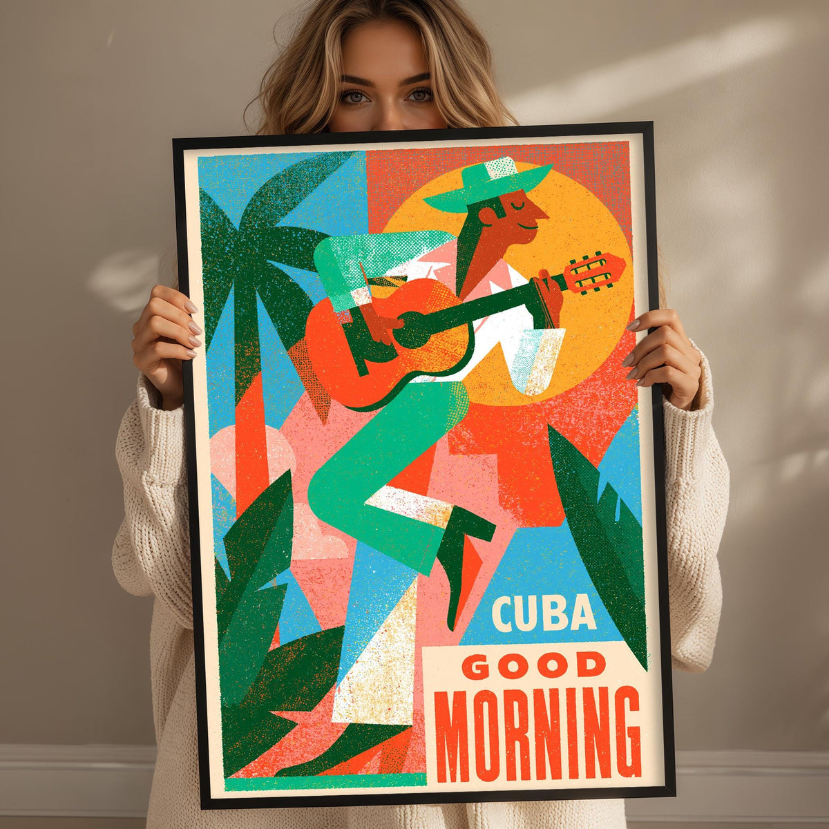 A woman holding a framed poster with a colorful illustration of a man playing guitar and palm trees.