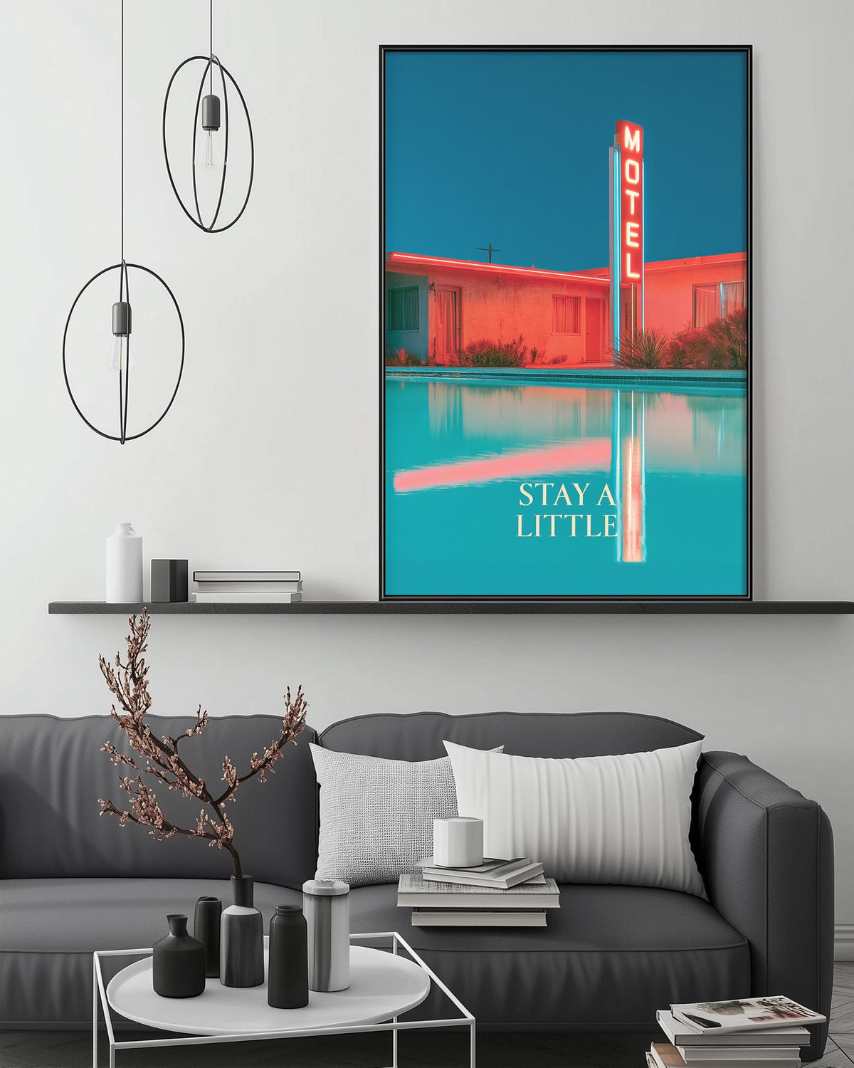 a modern living room with a gray sofa, a coffee table, and a large framed poster of a motel on the wall.