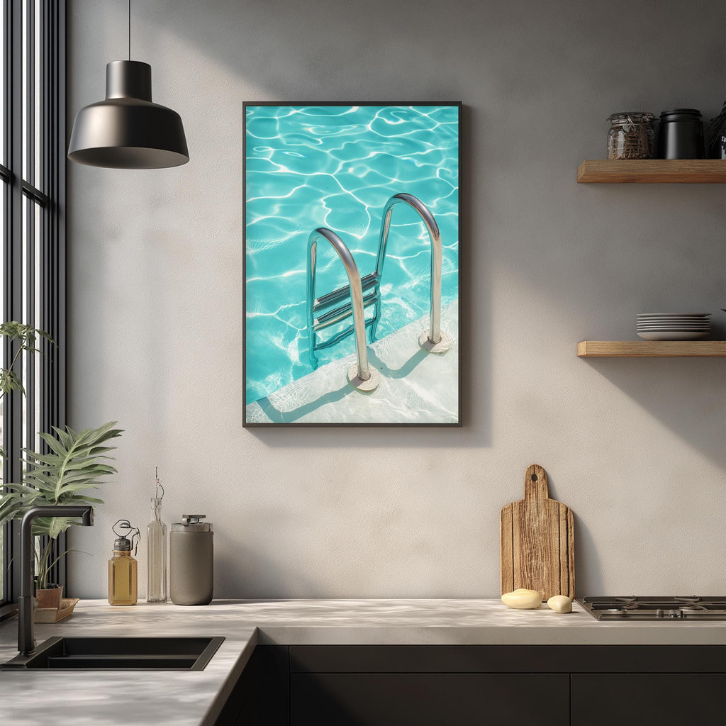 a framed photograph of a swimming pool with a ladder, hanging on a wall above a kitchen counter with various kitchen items and decor.