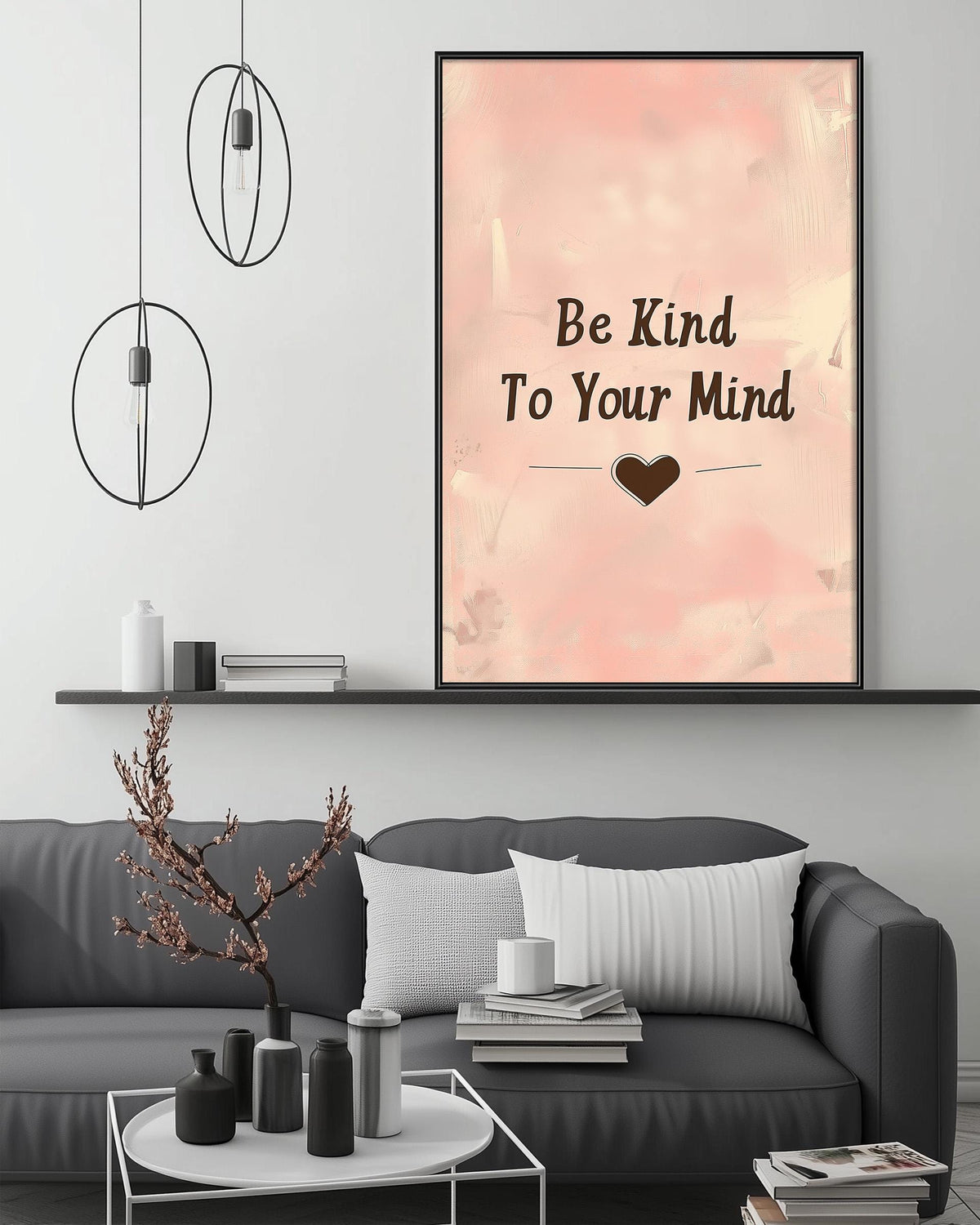 a living room with a gray couch, a coffee table, and a framed poster with the text "Be Kind To Your Mind" displayed on the wall above the couch.