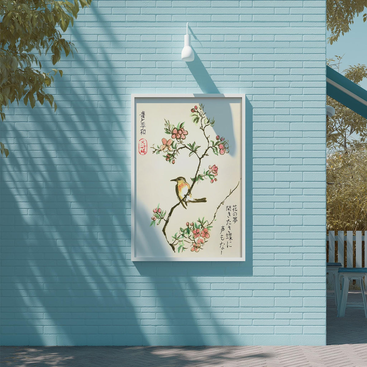 a blue brick wall with a framed painting of a bird perched on a branch with flowers. The painting is hung on the wall, and there is a light fixture above it.