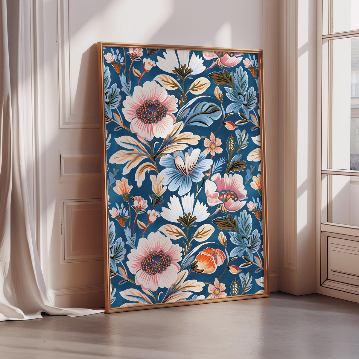 A large framed print with a vibrant floral pattern in shades of blue, pink, and orange is displayed on a wall in a room with a window.