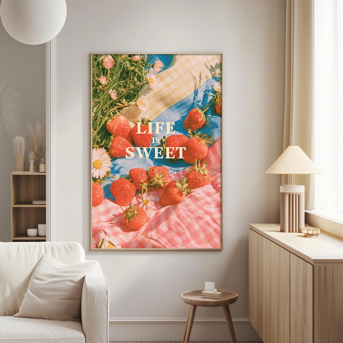 a large framed poster with a vibrant image of strawberries on a pink and blue background, hanging on a wall in a living room.