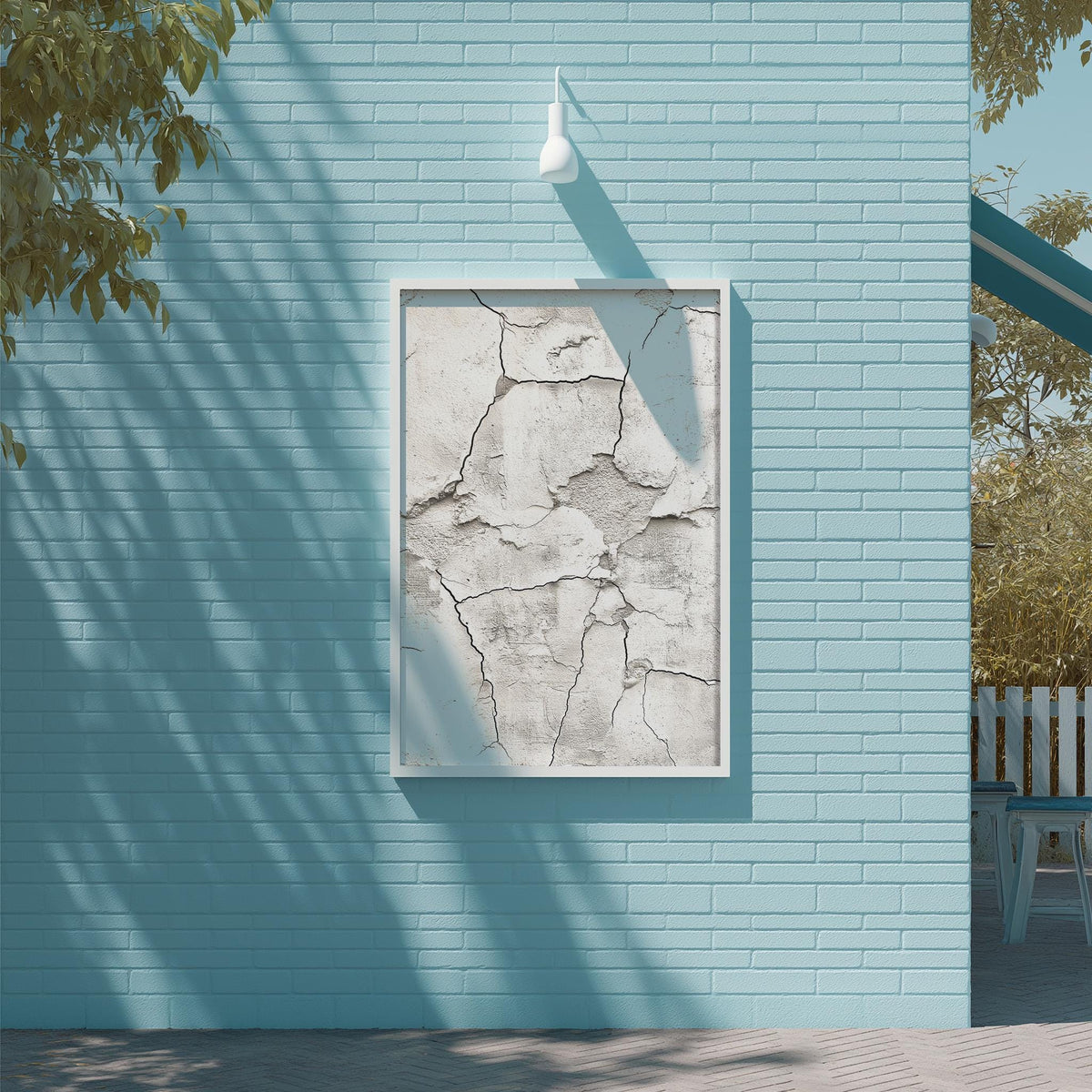 a blue brick wall with a white frame containing a large, cracked white piece of artwork. The artwork is displayed on the wall, creating a striking contrast between the white and blue colors.