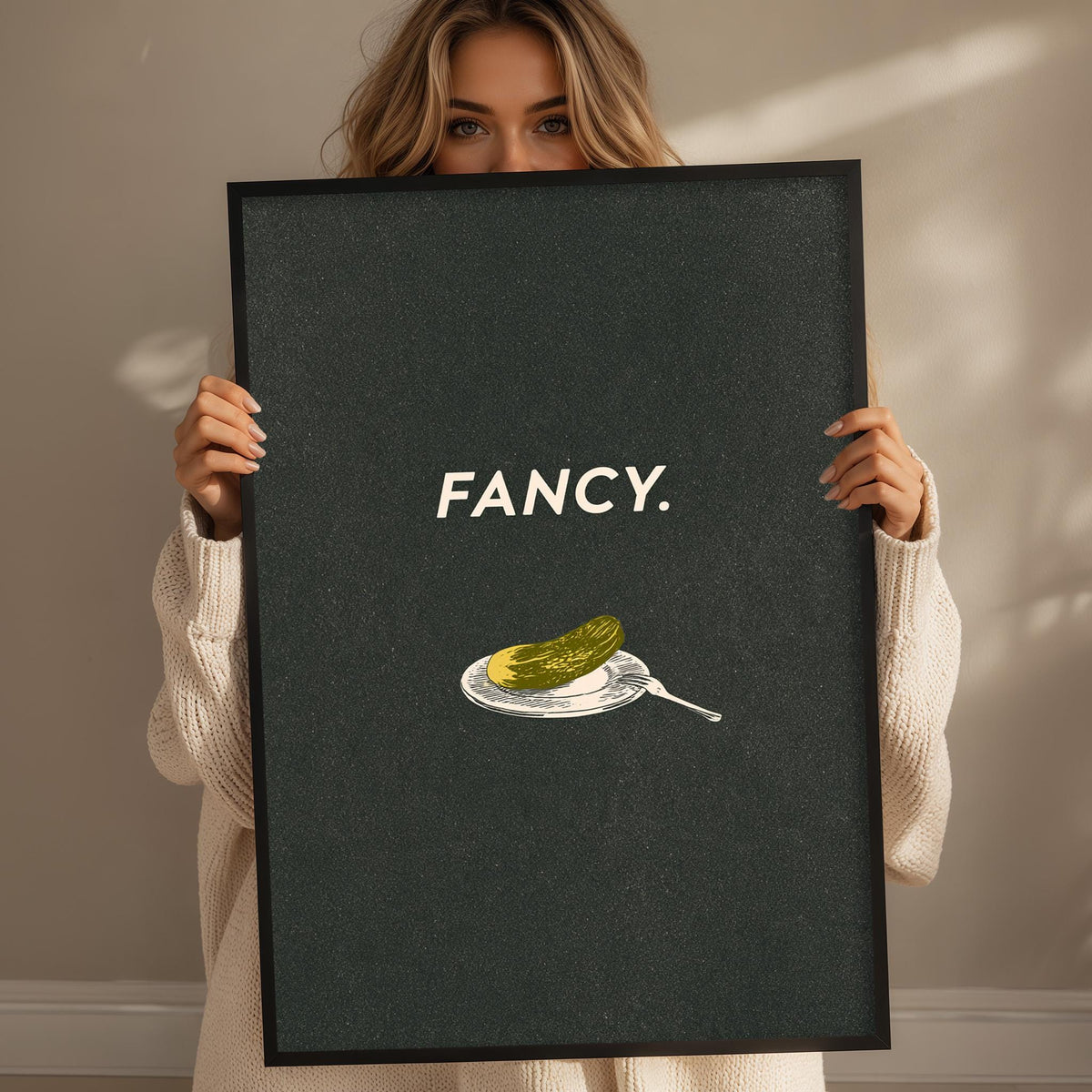 A woman holding a framed poster with the word "FANCY" on it.