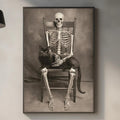 a skeleton sitting in a chair with a cat on its lap, displayed on a wall in a kitchen setting.