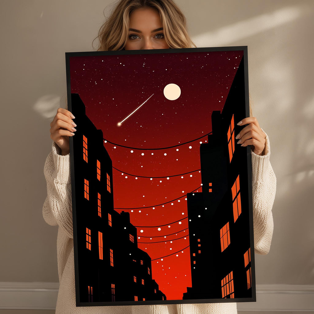 A woman holds up a framed poster depicting a nighttime cityscape with a full moon, stars, and a string of lights.