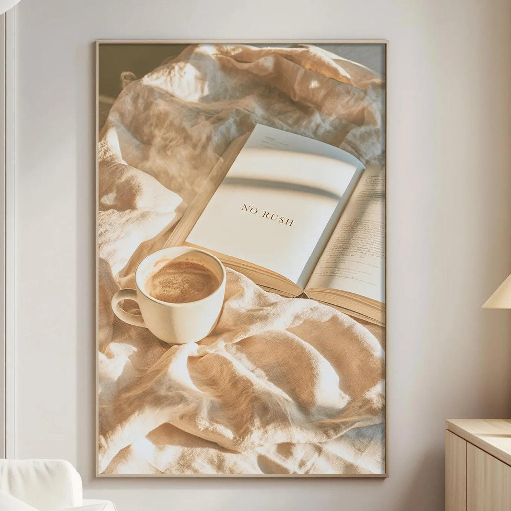 a cozy living room with a white sofa, a wooden side table, and a framed picture of a cup of coffee and an open book on a blanket.