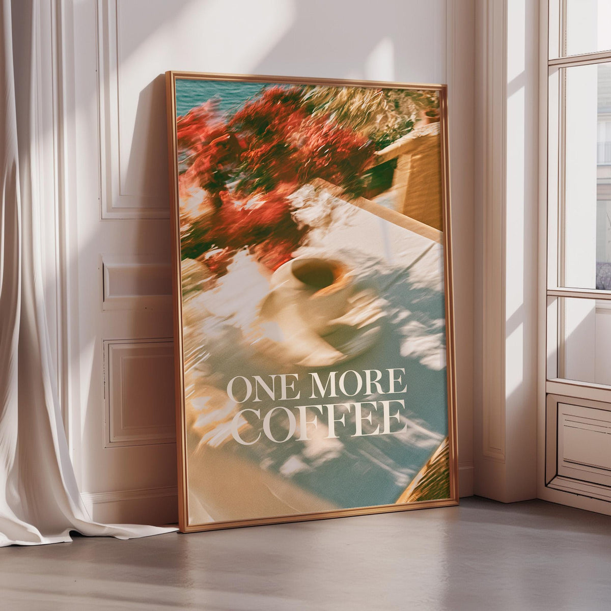 A framed poster with a blurred image of a coffee cup and flowers, along with the text "ONE MORE COFFEE" displayed prominently on the poster.