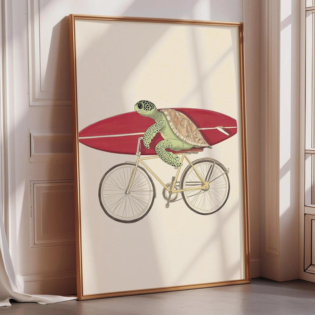 A framed illustration of a green sea turtle riding a red bicycle, with a surfboard attached to the back.