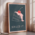 A framed poster with a drawing of a slice of cake and the text "Nailed it."