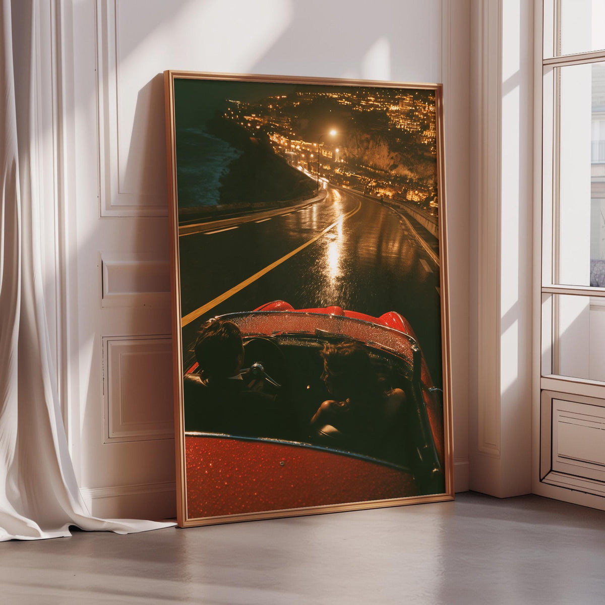 A framed photograph of a red convertible car on a road at night, with the car's headlights illuminating the road and the surrounding area.