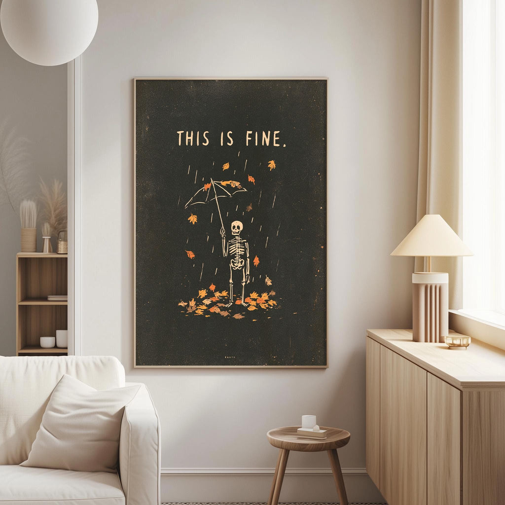 a living room with a large black framed poster on the wall that says "THIS IS FINE." The poster depicts a skeleton holding an umbrella, surrounded by falling leaves. The room also includes a white couch, a small table, and a lamp.