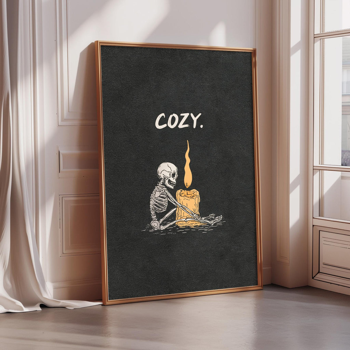 A framed poster with a skeleton holding a lit candle, accompanied by the word "COZY" in white text.