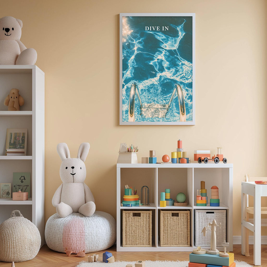 A child's bedroom with a white bookshelf, a stuffed rabbit, and a colorful toy box filled with toys. Above the bookshelf is a framed poster with a blue ocean scene and the word "DIVE IN".