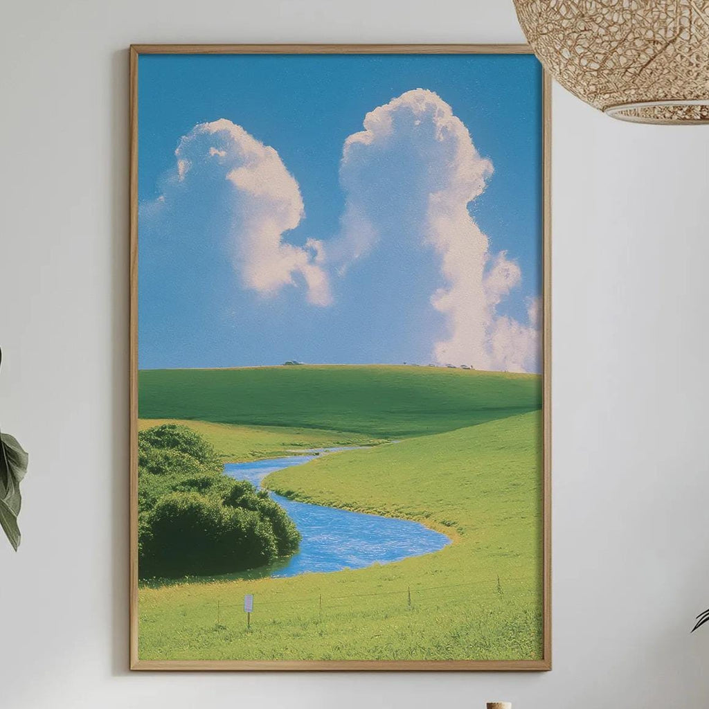 a serene landscape with a winding river, lush green fields, and a clear blue sky with fluffy white clouds. The scene is framed and hung on a wall above a dining table, which is set with various items such as a bottle, a bowl, and a vase. The table is surrounded by chairs, and the room is decorated with potted plants and other natural elements, creating a peaceful and inviting atmosphere.