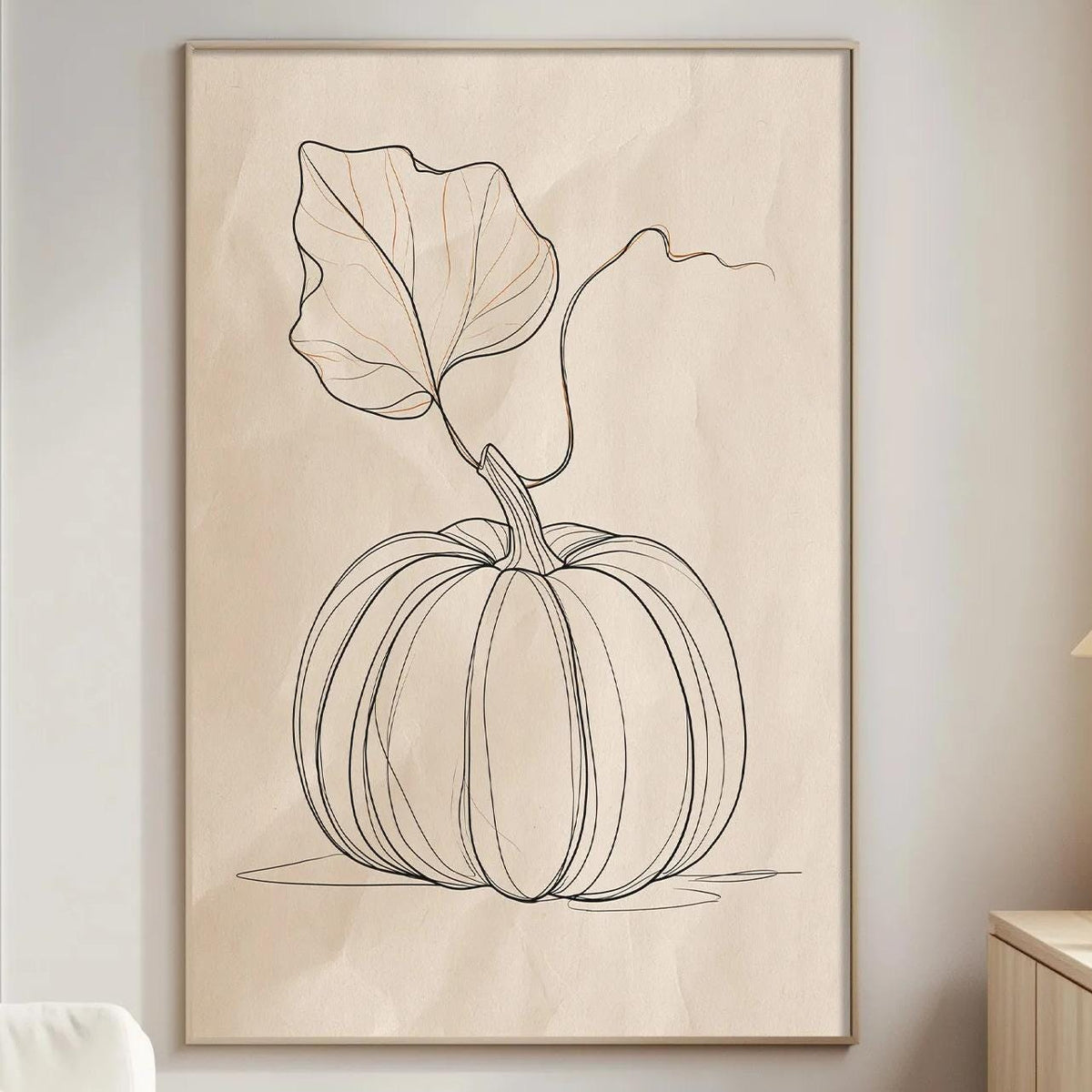 a living room with a white sofa, a wooden side table, and a framed drawing of a pumpkin on the wall.