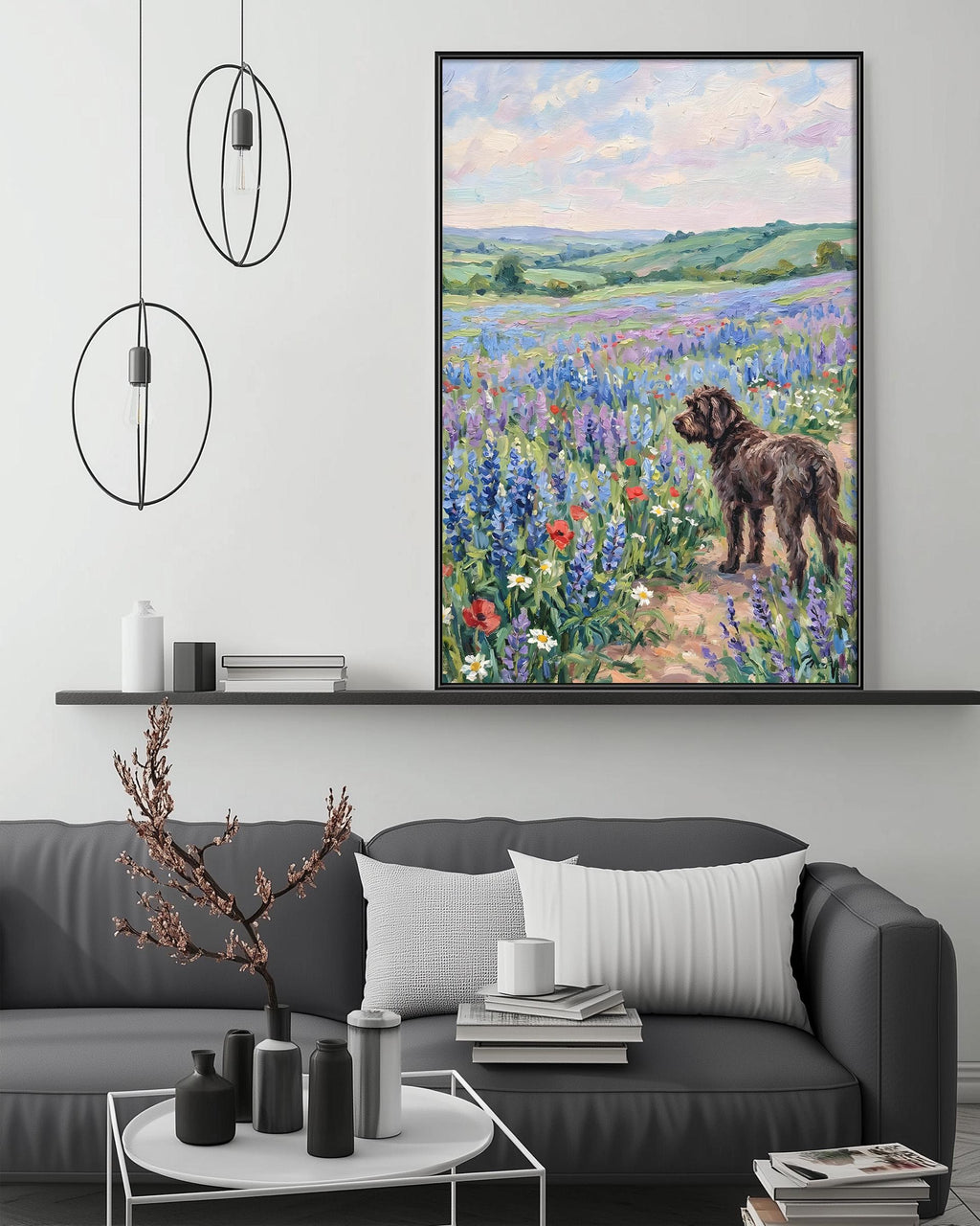 a large painting of a dog standing in a field of flowers, with a serene landscape in the background. The painting is hung on a wall above a gray couch, which has a coffee table in front of it. The room also includes a shelf with decorative items and a potted plant.