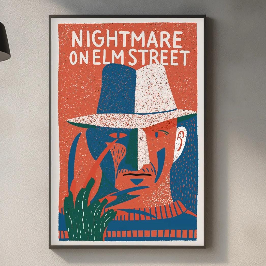 a kitchen counter with a framed poster of a man's face hanging above it. The poster has a colorful design and the text "NIGHTMARE ON ELM STREET" written on it.