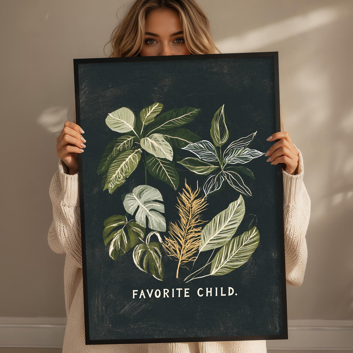 A woman holding a framed print with a plant illustration on it, with the text "Favored Child" written on the bottom of the frame.