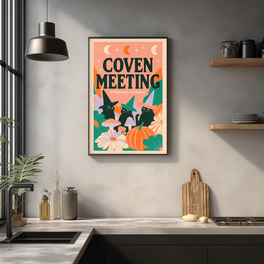 a kitchen counter with a framed poster of a witch and cat illustration hanging on the wall above it.