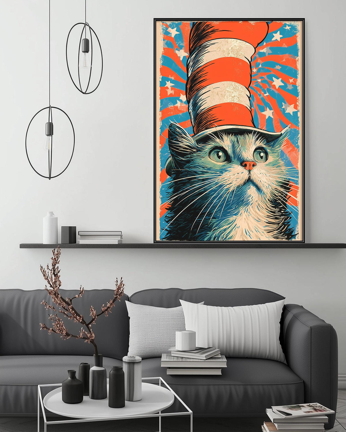 a large framed poster of a cat wearing a red, white, and blue striped hat, with a colorful background. The poster is displayed on a wall above a gray couch, which has a coffee table in front of it. The room also includes a shelf with various decorative items, and a potted plant on the floor.