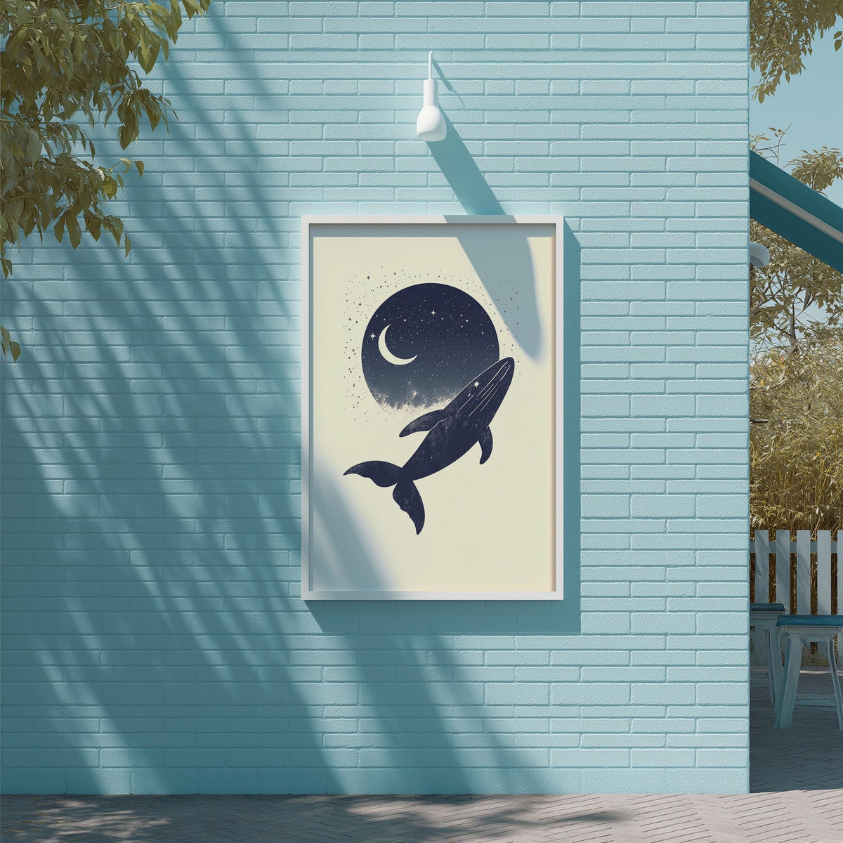 a blue wall with a framed poster of a whale and a crescent moon hanging on it.