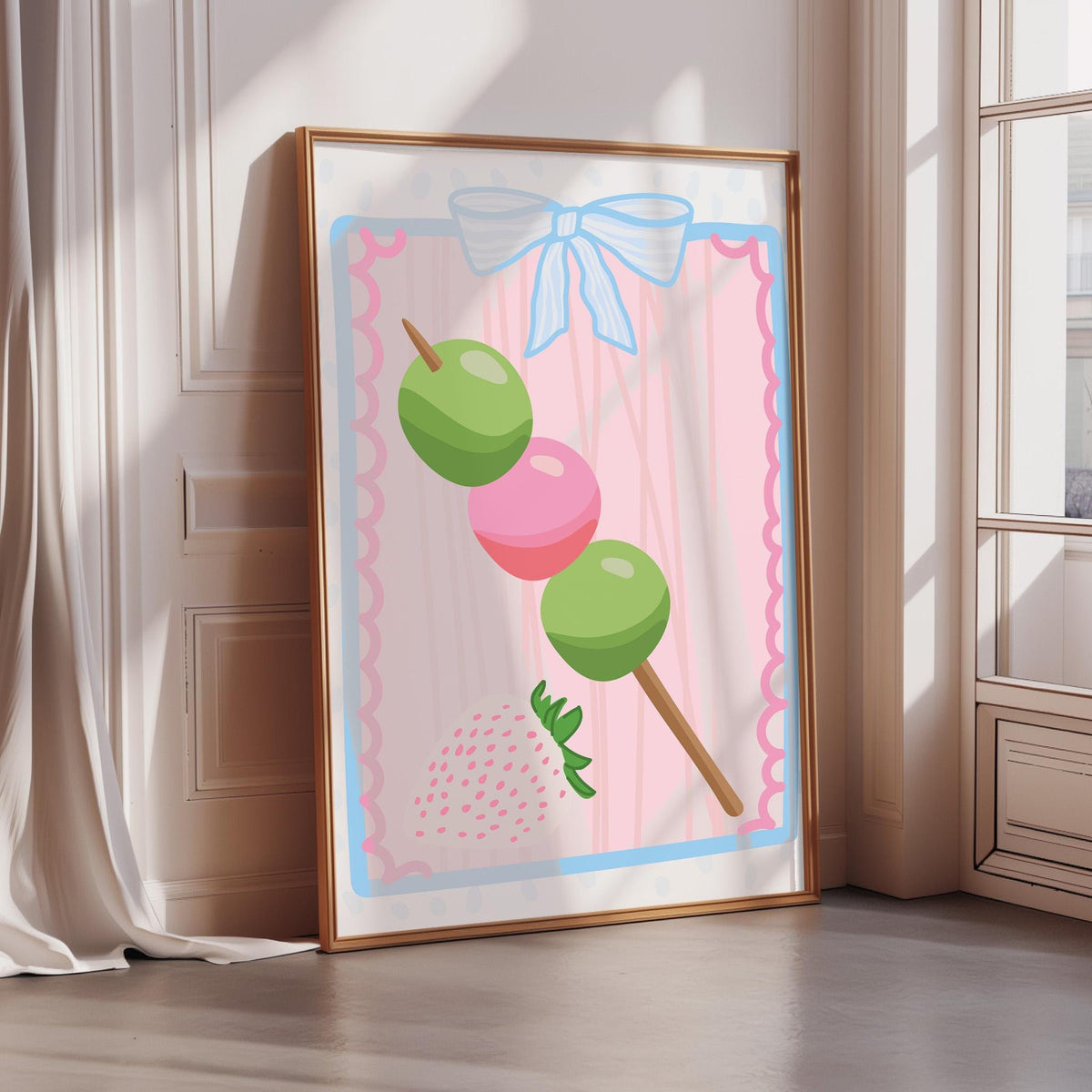 A framed illustration of a green and pink fruit skewer with three green fruits on it, placed on a white wall.