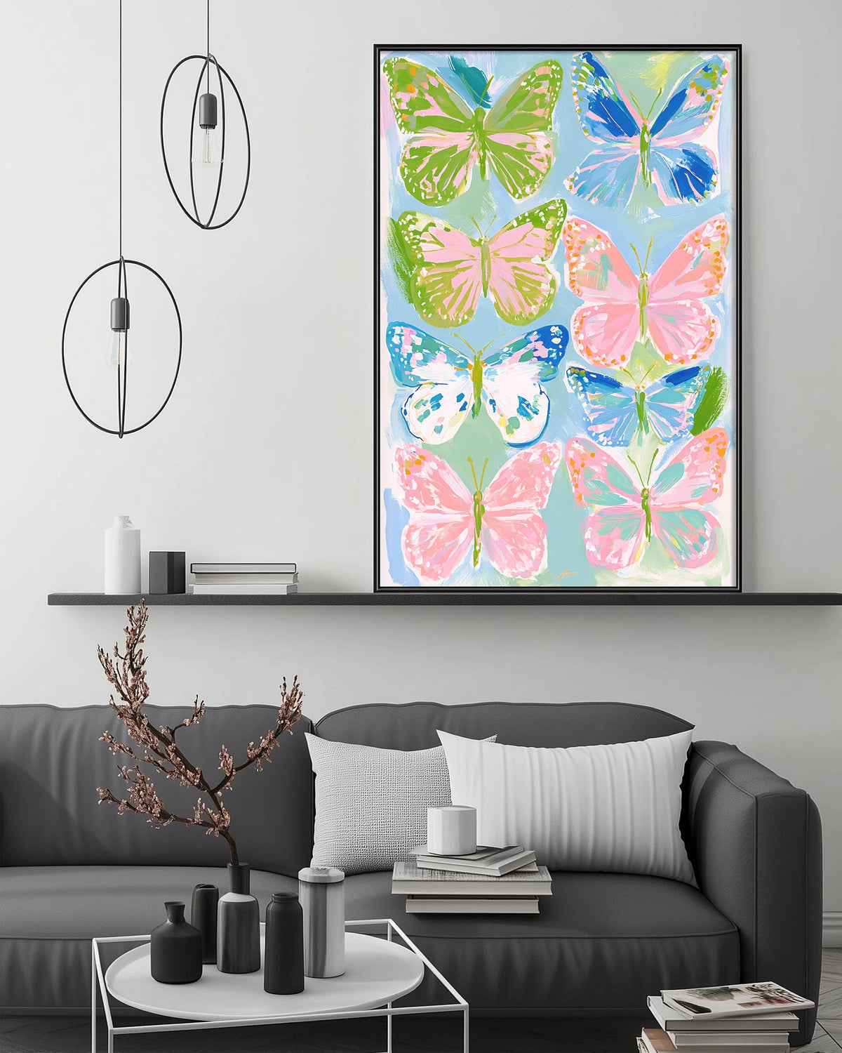 a large, colorful painting of butterflies hanging on a wall above a gray couch in a living room setting.