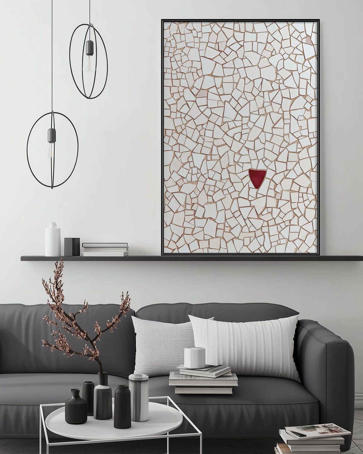 a modern living room with a gray sofa, a coffee table, and a large abstract painting on the wall. The painting has a mosaic-like pattern with a red triangle in the center. The room has a minimalist and contemporary design, with a black pendant light hanging above the sofa and a white shelf below the painting.