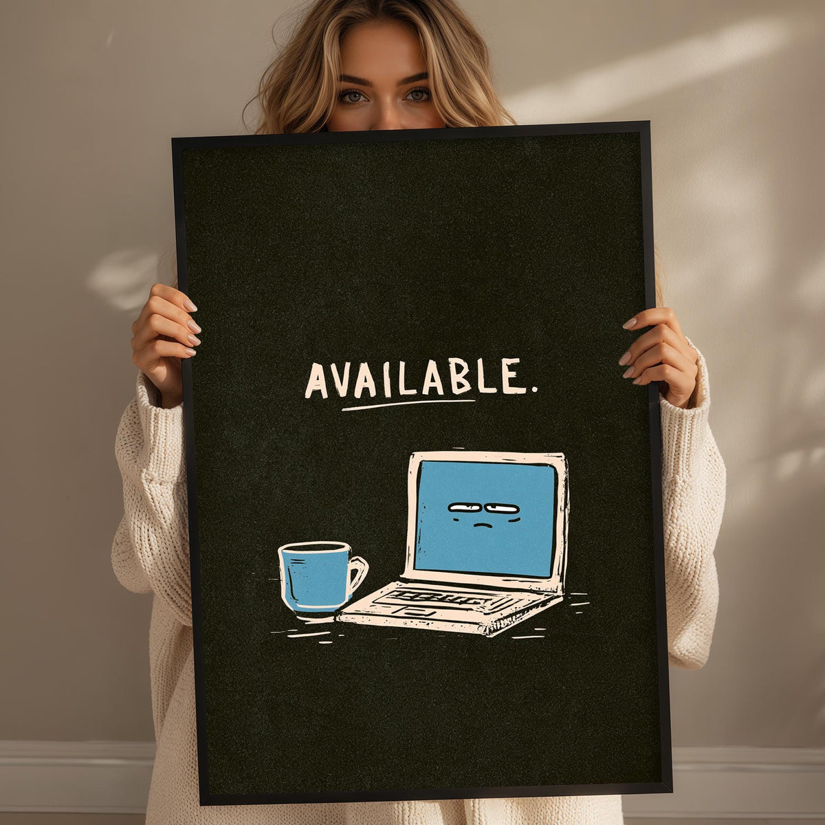 A woman is holding a framed poster with a laptop and a coffee mug on it, and the text "AVAILABLE."