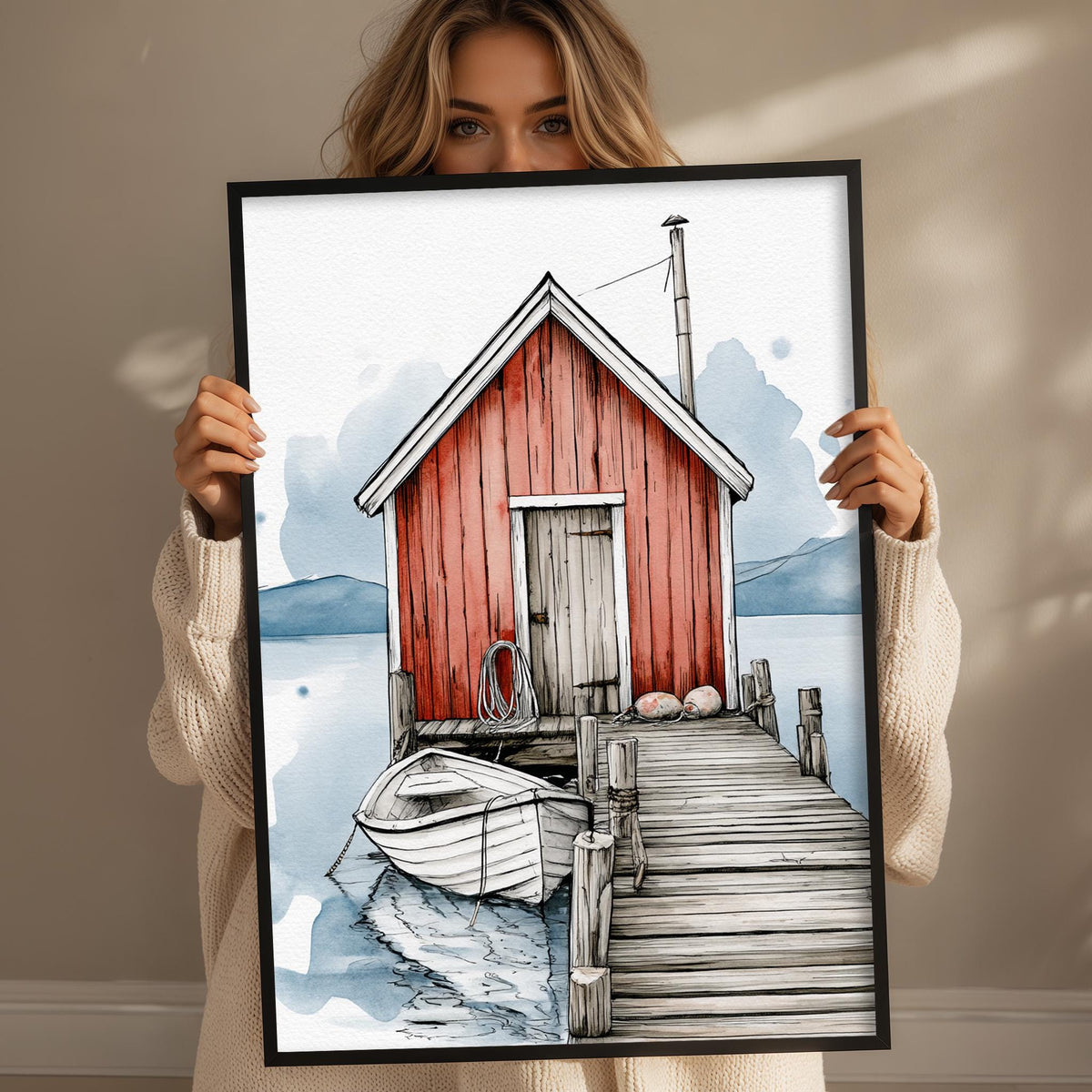 A woman holds up a framed painting depicting a red wooden cabin with a dock and a small boat, set against a serene landscape.