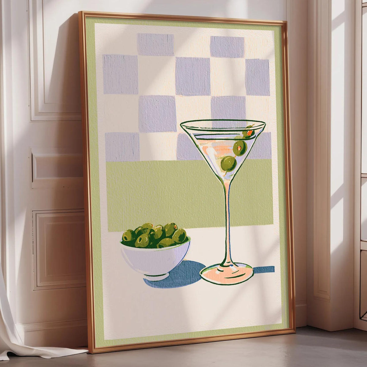 a framed illustration of a martini glass with olives and a bowl of olives, set against a checkered background.
