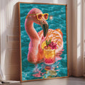 A framed painting depicting a pink flamingo wearing sunglasses and holding a drink, surrounded by a turquoise background.