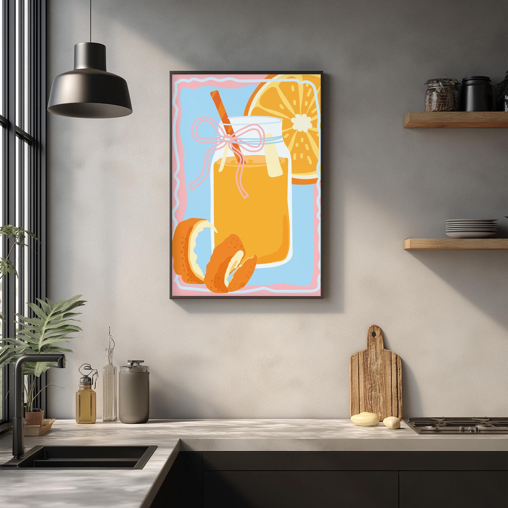 a kitchen counter with a framed illustration of a glass jar containing orange juice, a slice of orange, and a wooden cutting board.