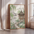 A framed painting depicting a serene Japanese garden scene with a traditional Japanese pavilion, surrounded by lush greenery and a tranquil pond.