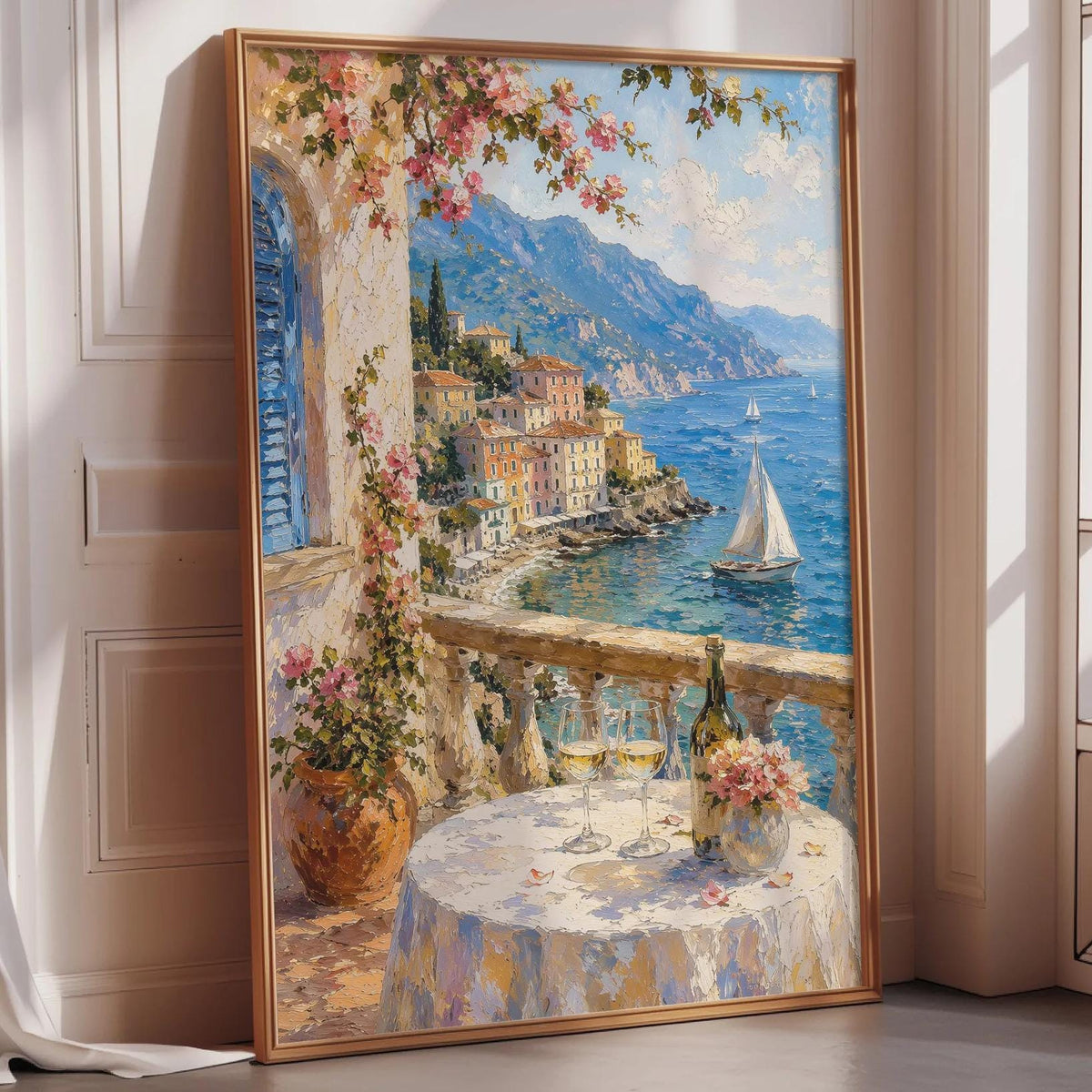 The image is a framed painting depicting a picturesque coastal scene with a sailboat on the water, a table with wine glasses, and a balcony overlooking the ocean.