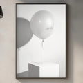 a minimalist kitchen scene with a framed picture of a white balloon with the word "pride" on it, a wooden cutting board, and various kitchen items such as a sink, a bottle, and a vase.