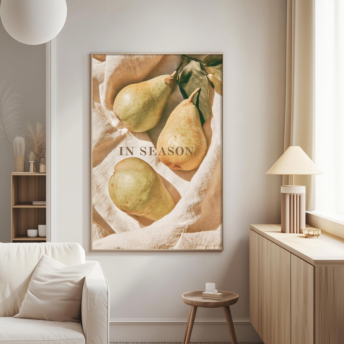 a living room with a large framed print hanging on the wall, depicting three pears on a blanket. The print has the text "IN SEASON" written on it.