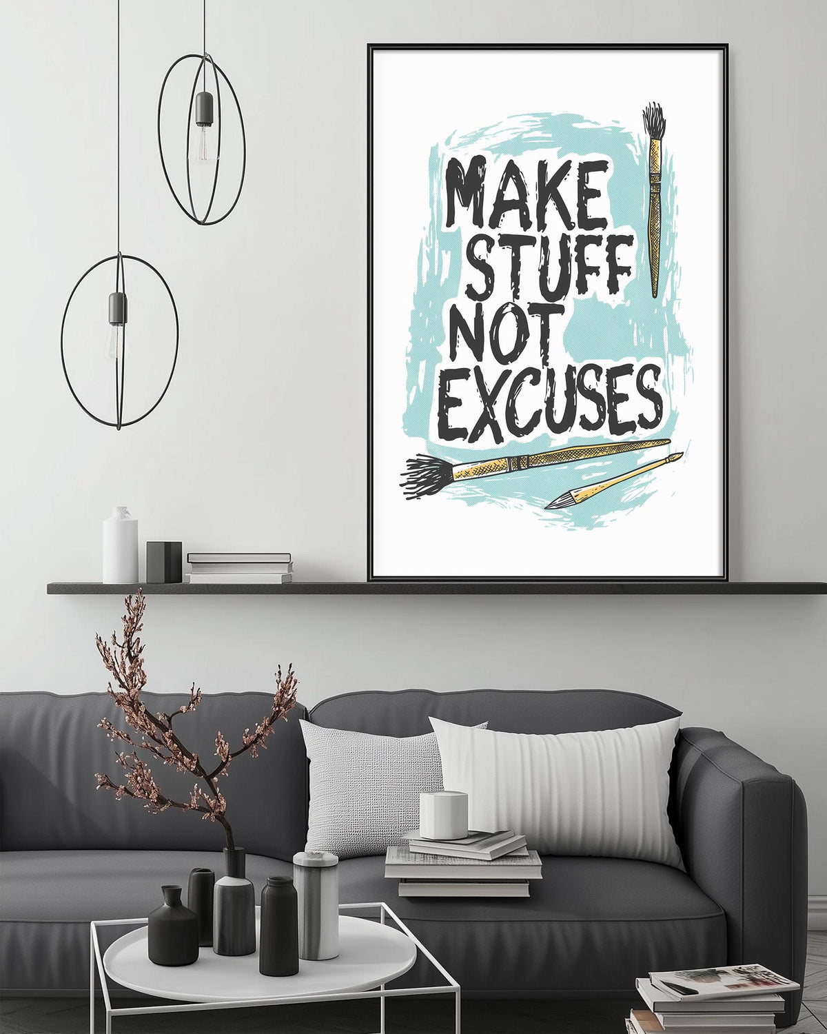 a living room with a gray couch, a coffee table, and a framed poster with the text "MAKE STUFF NOT EXCUSES" displayed on the wall above the couch.