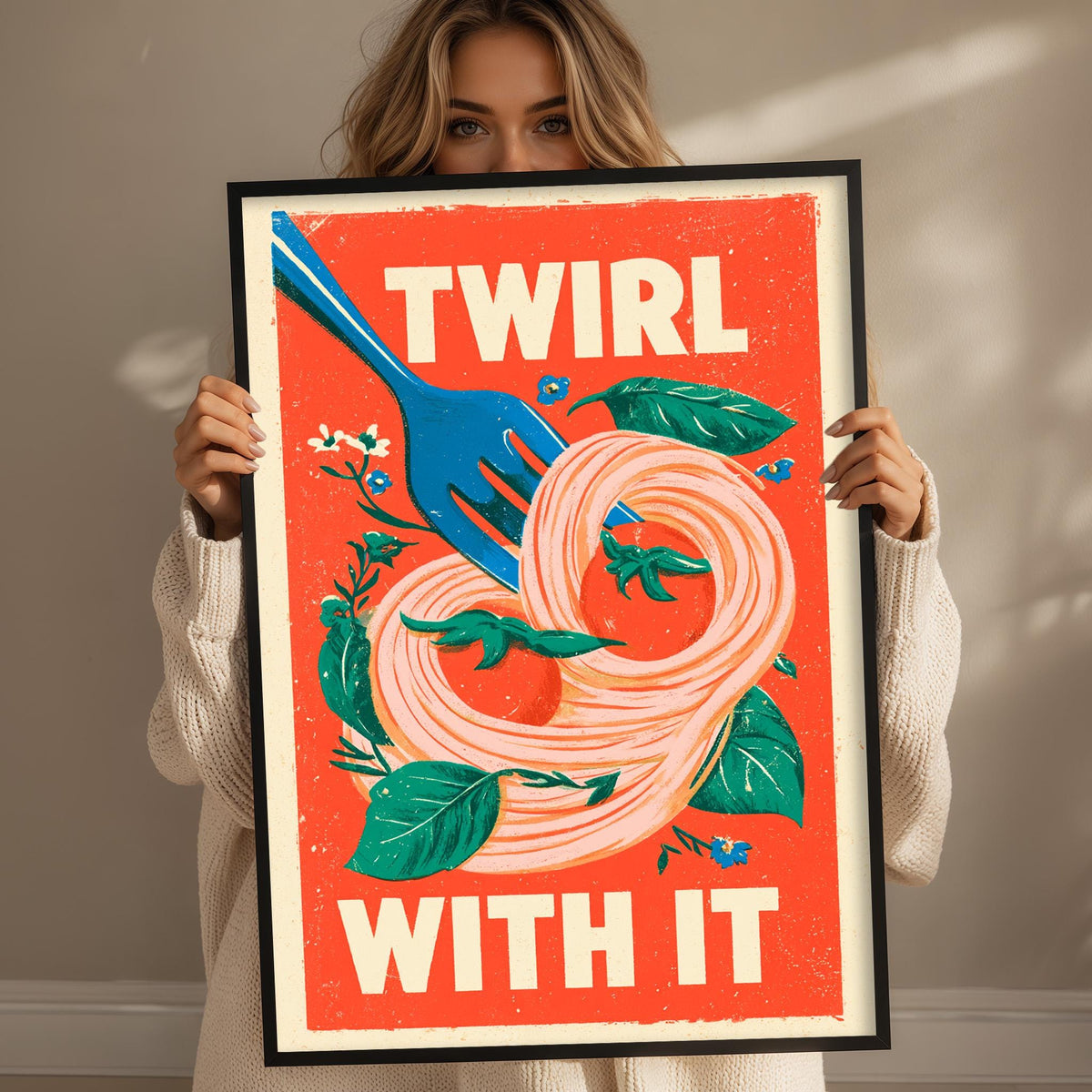 A woman is holding up a framed poster with a vibrant design featuring a fork and noodles.